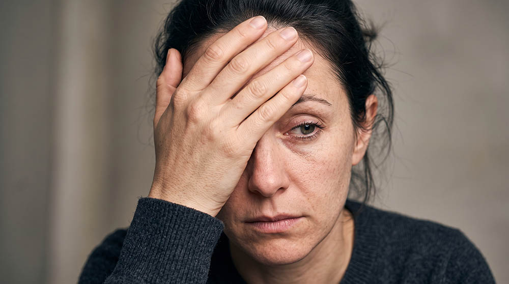 Middle Aged Woman Holding Head with Tired or Stressed Facial Exp